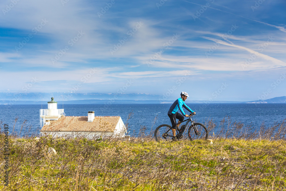 Fototapeta premium Mountainbiker mit Ebike am Meer