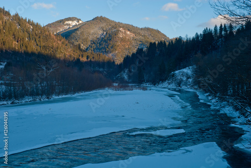 Winter mountain landscape with ice covered river