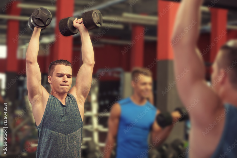 Athletic man training with dumbbells in gym Athletic man training with dumbbells in gym