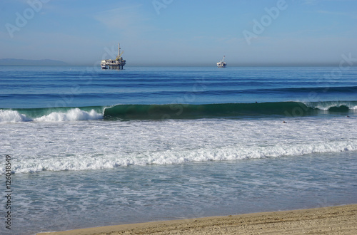 oil platforms and surfers in pacific ocean