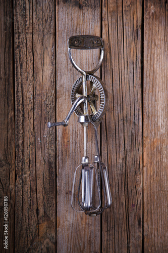 Whisk Beating Eggs on wooden background.Hand mixer.Vintage style.Top view. Space for text.