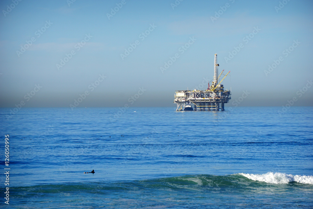 oil platform and surfer in ocean oil platform and surfer in ocean