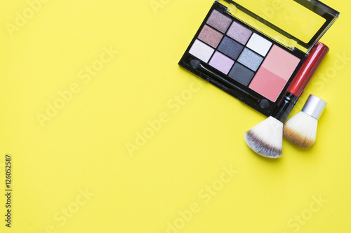 Set of colorful cosmetics on yellow background