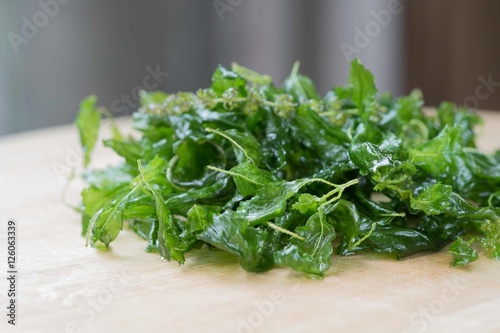 Holy basil fried on a wooden cutting board
