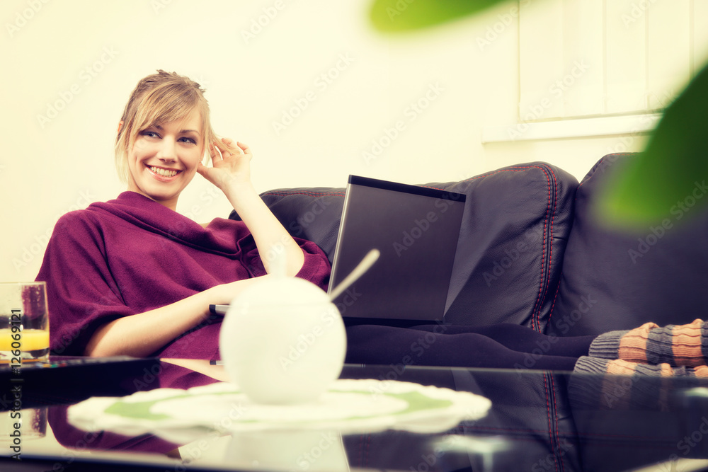 Young woman with blond hair working on her laptop at home Young woman with blond hair working on her laptop at home
