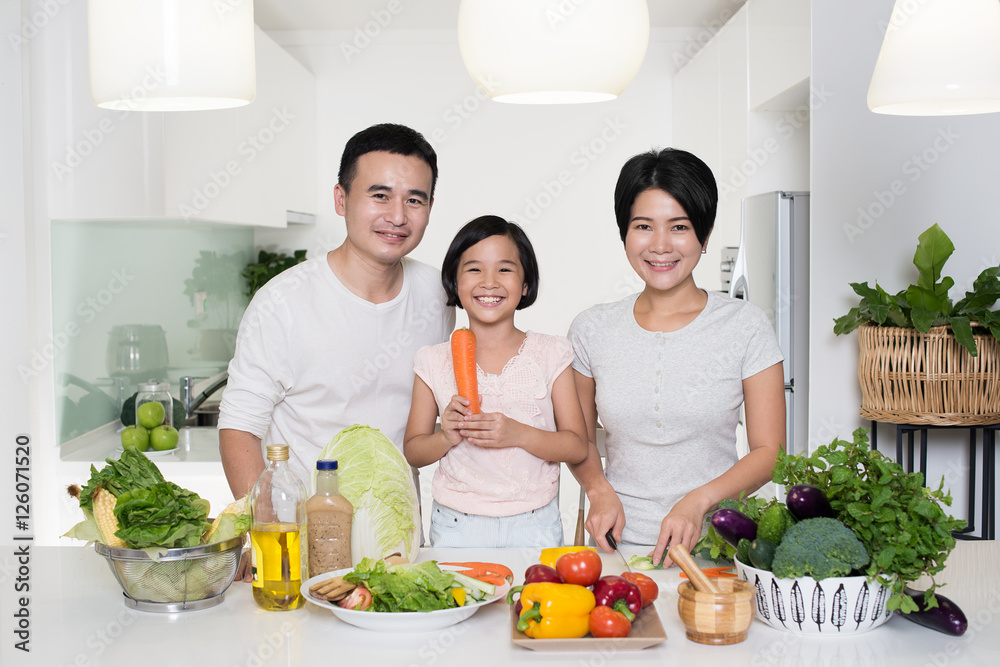 Happy Asian family preparing food in the kitchen. Happy Asian family preparing food in the kitchen.