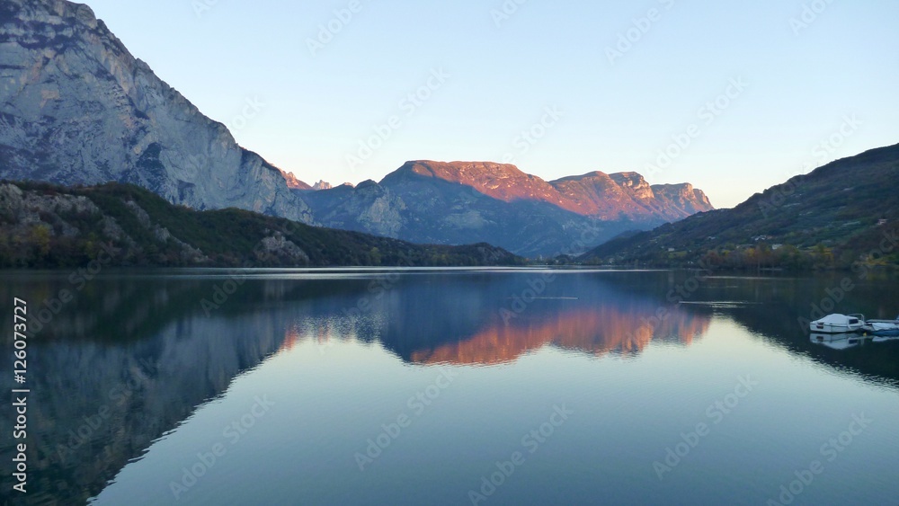 reflection of mountains in water of lago Cavedine