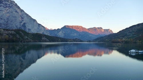 reflection of mountains in water of lago Cavedine