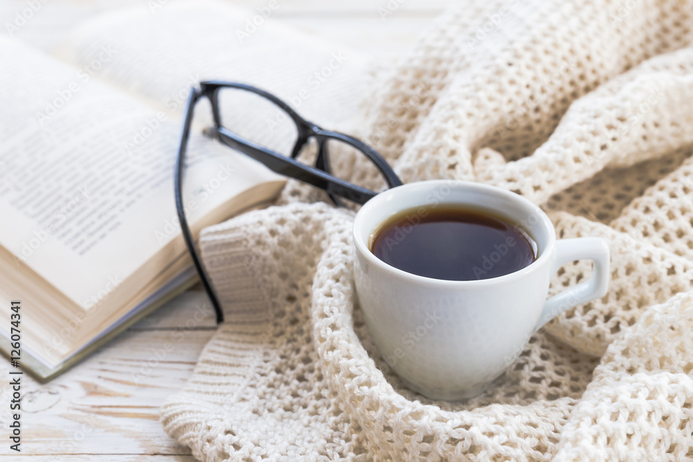 Warm knitted plaid, glasses, cup of hot coffee and book Warm knitted plaid, glasses, cup of hot coffee and book