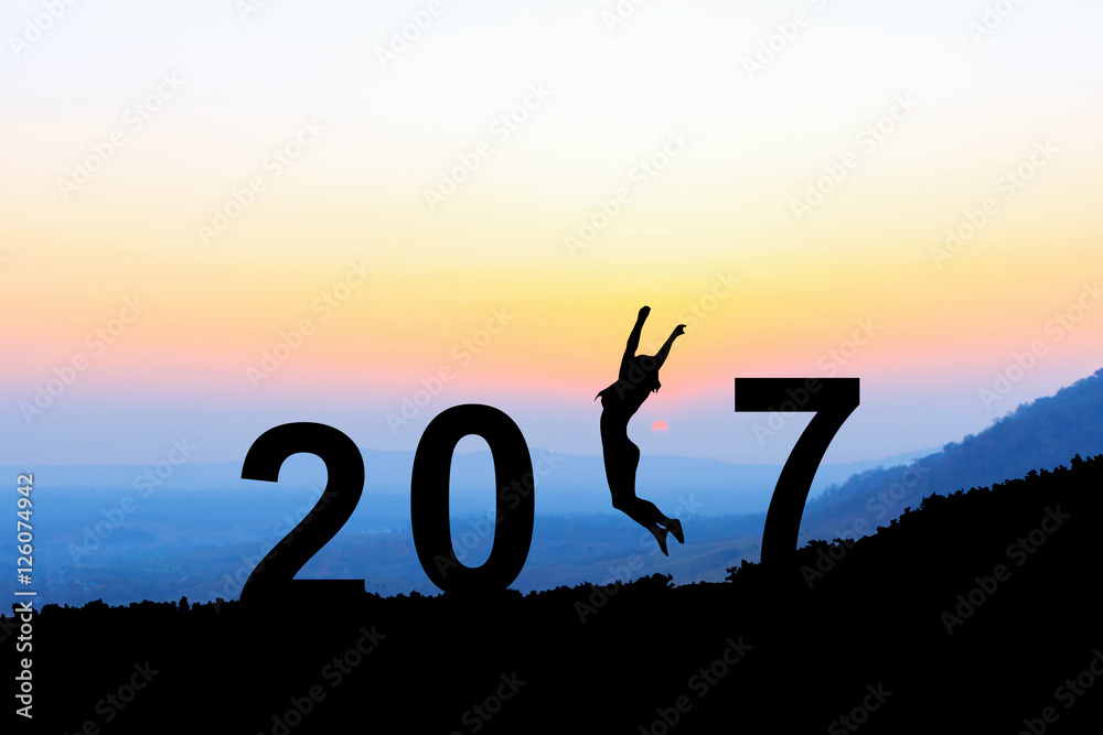 Silhouette young woman jumping over 2017 years on the hill at su Silhouette young woman jumping over 2017 years on the hill at su