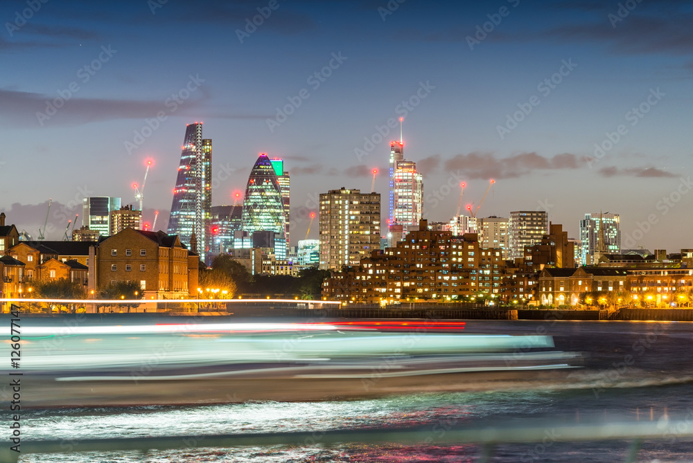 Fototapeta premium Blurred ferry light trails with London City skyline, night view