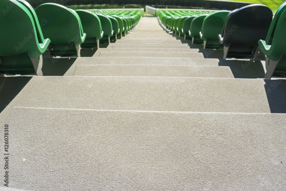 Naklejka premium Pass down between the seating rows in a stadium with weathered chairs