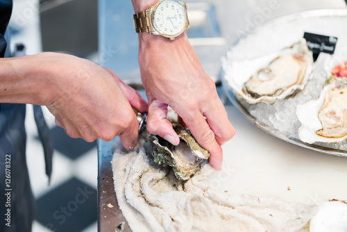 Shucking fresh oysters with a knife
