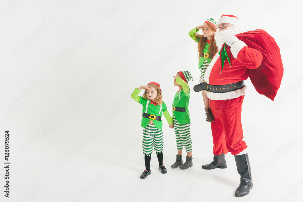 Santa Claus and Kids dressed in Elven costumes. North Pole.