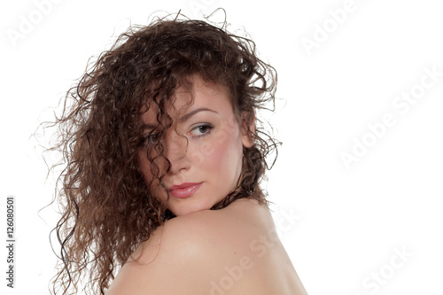 young woman with curly hair posing on a white background