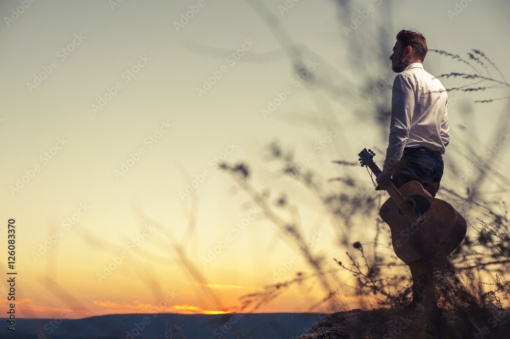 Fototapeta premium Portrait of young man in holding acoustic guitar