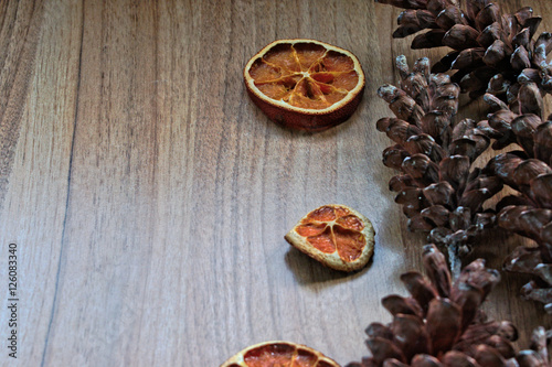 Dried orange slices and pine cones on a wooden table