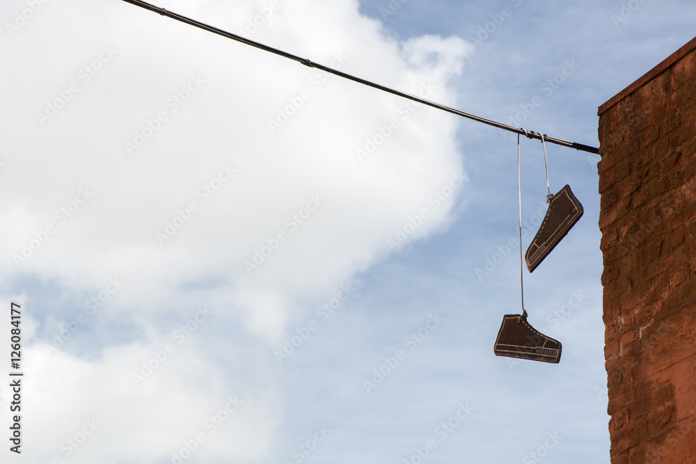 Two cardboard gumshoes in the blue sky with white clouds Two cardboard gumshoes in the blue sky with white clouds