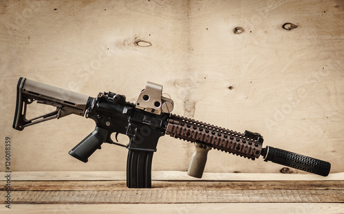 black assault rifle on a light wooden table