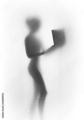 Slihouette of a young beautiful standing woman with laptop computer