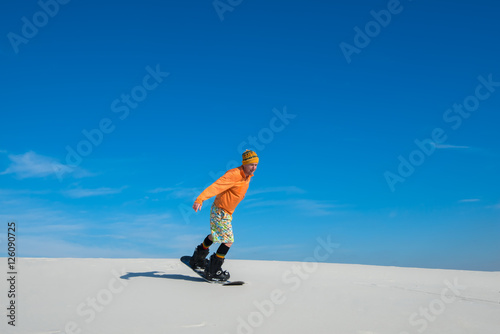 Man making a trick on snowboard on sand slope