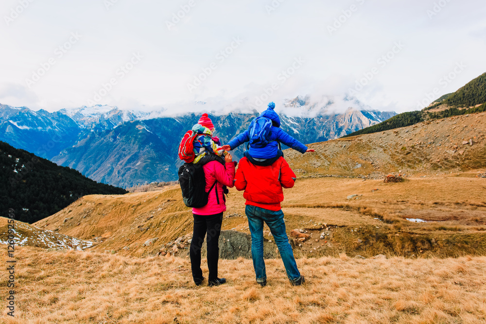 family with two kids hiking in winter mountains