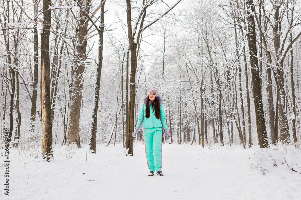 Portrait of a cute brunette in a frosty park.