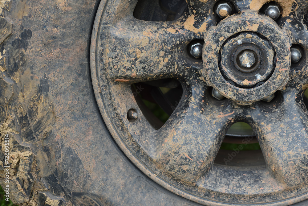 Color detail shot of an off-road car's wheel, covered in mud