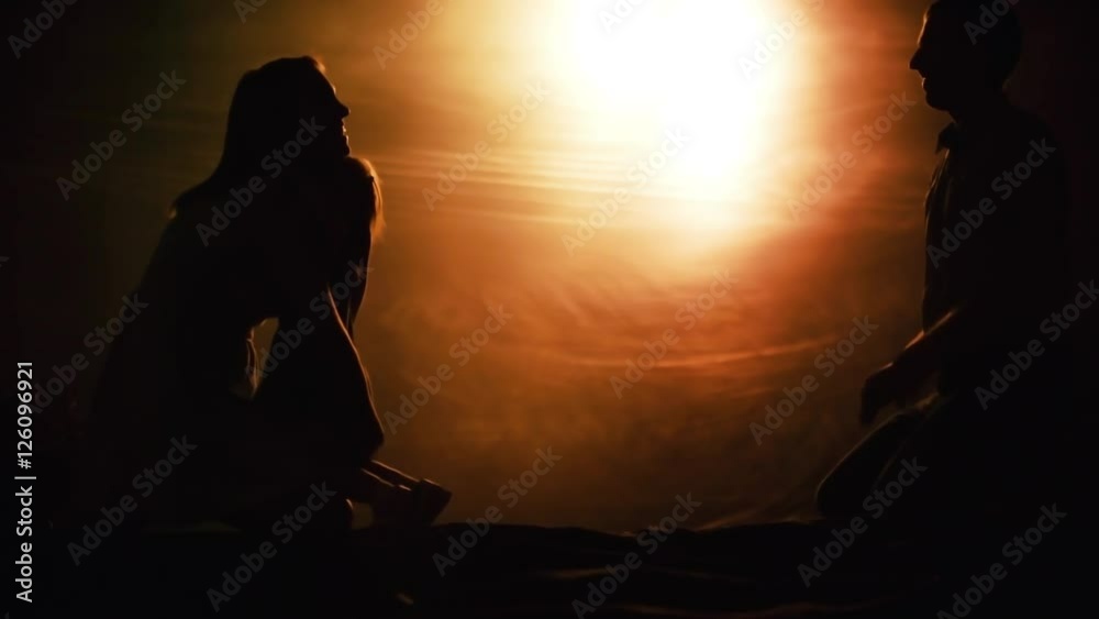 Silhouettes of little toddler girl running from loving father towards mother, then hugging ad kissing 