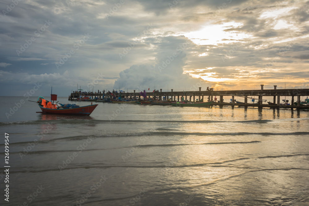 Fishing boats in the sea and a beautiful sky while the sunset, at harbour bridge,  Chao Lao Beach,  Chanthaburi, Thailand.