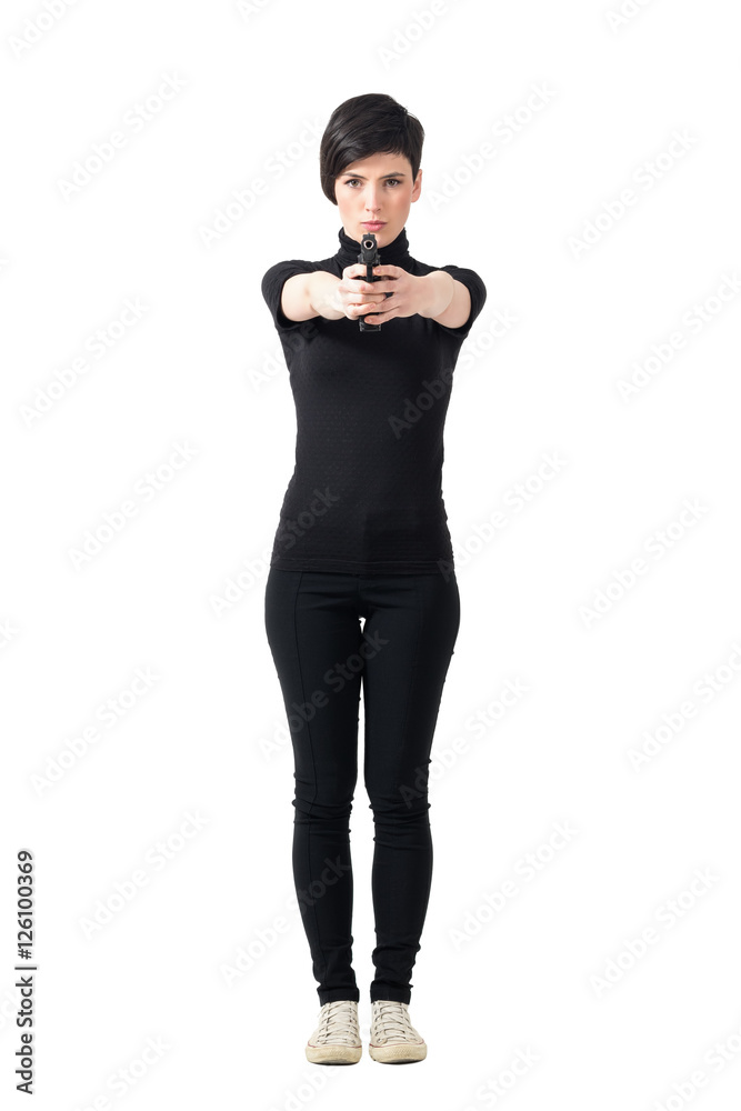 Dangerous tough female spy in black clothes aiming gun at camera. Full body length portrait isolated over white studio background. Dangerous tough female spy in black clothes aiming gun at camera. Full body length portrait isolated over white studio background.