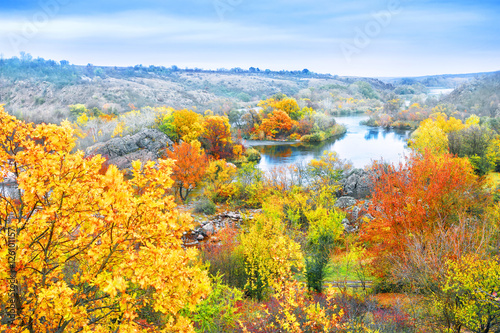Bright autumn trees on the bank of stream © alexlukin