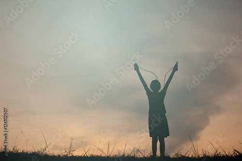 Silhouette young girl rope jumping on the sunset. Time on holiday happy and fun , vintage tone