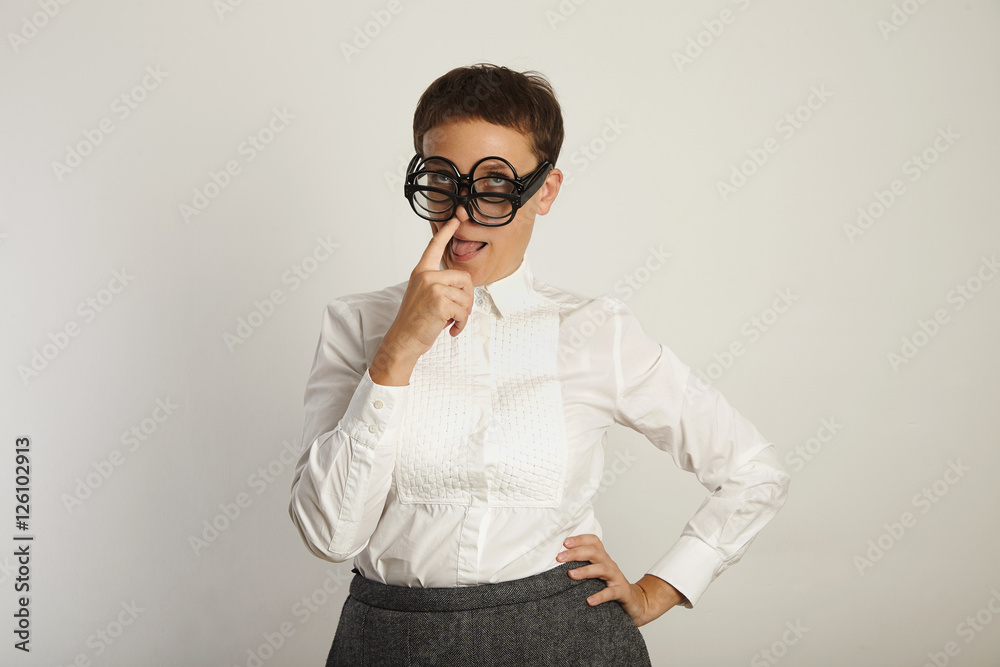 Crazy female teacher in three pairs of glasses sticks out her tongue and picks her nose isolated on white Crazy female teacher in three pairs of glasses sticks out her tongue and picks her nose isolated on white
