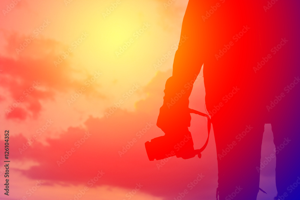 Silhouette women with camera on the sky sunset concept travel ,alone in nature ,vintage tone Silhouette women with camera on the sky sunset concept travel ,alone in nature ,vintage tone