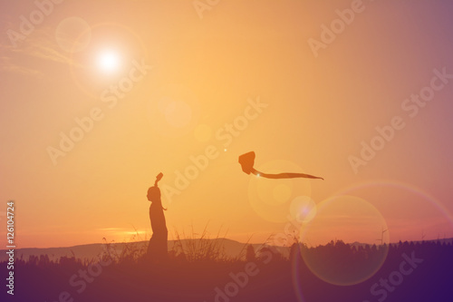 Silhouette of children playing kite on field in harvest season Happy farmer at sky sunrise in the morning