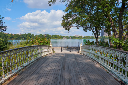Looking over a small bridge with wood planks to the Jacqueline Kennedy Onassis Reservoir in Central Park in New York City