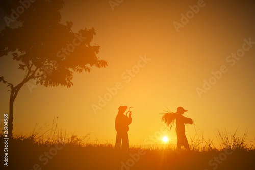 Silhouette of children holding rice on field in harvest season,Happy farmer at sky sunrise in the morning