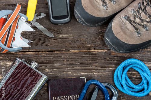 Equipment for mountaineering and hiking on wooden background.