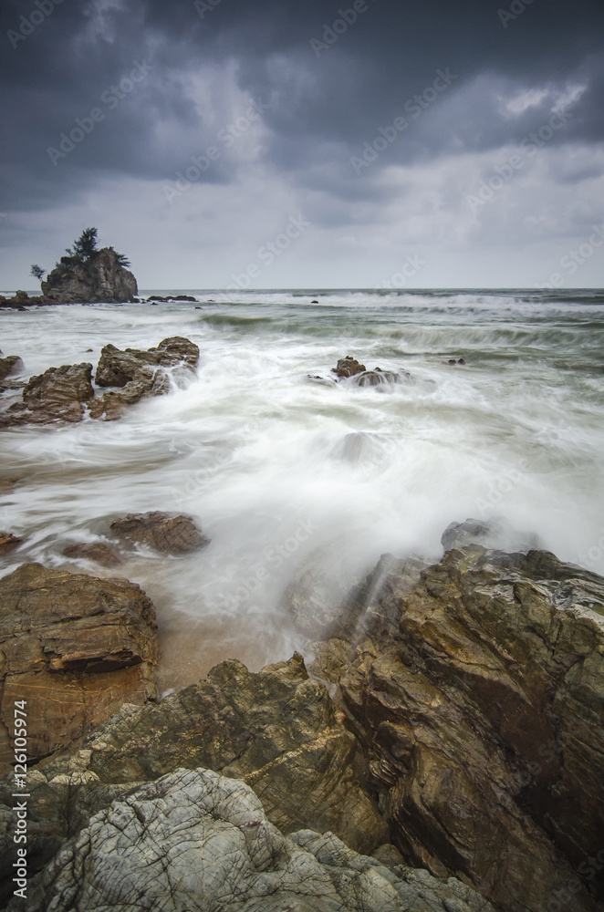beautiful beach with rock hitting by waves. soft focus due to lo beautiful beach with rock hitting by waves. soft focus due to lo
