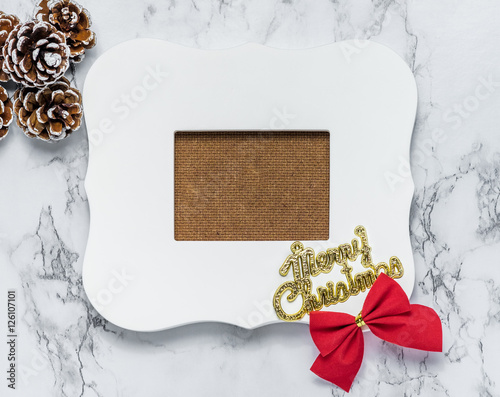 Merry christmas text on vintage white picture frame with pine co photo