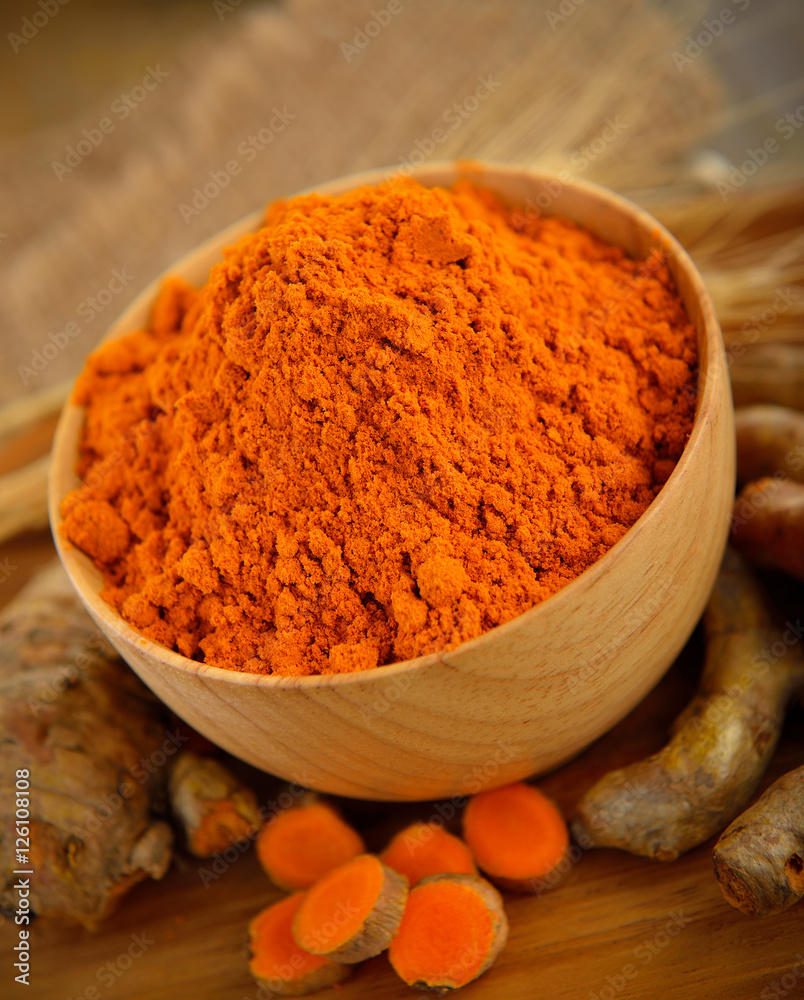 Turmeric and turmeric powder on wooden background Turmeric and turmeric powder on wooden background