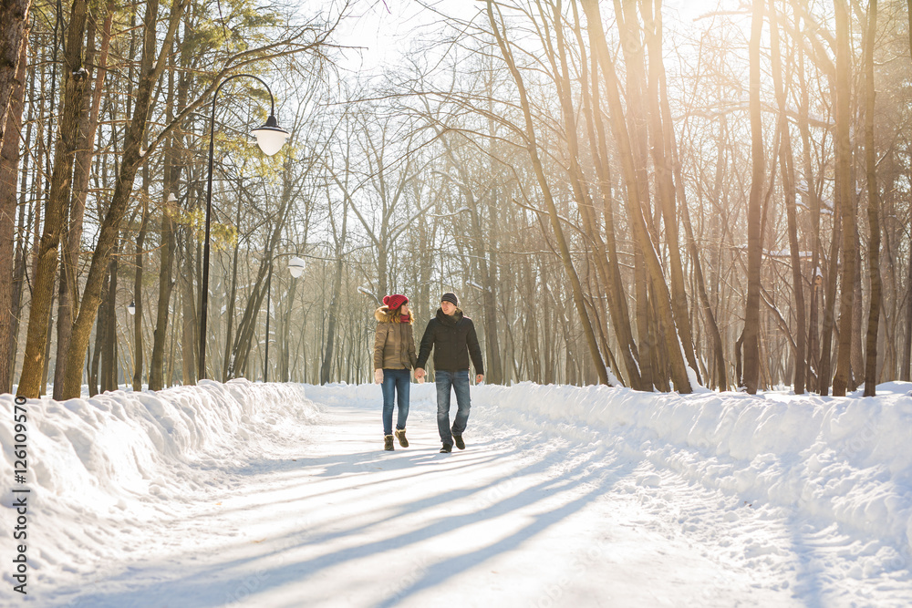 Young couple in love walking in the snowy forest