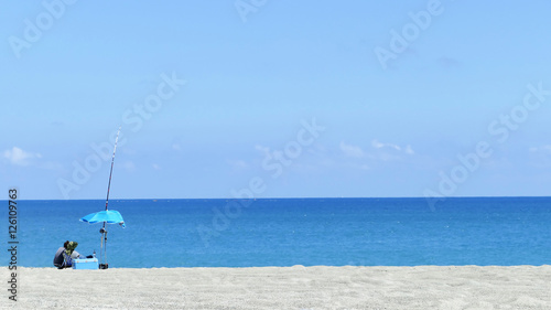 Man fishing on beach with nice background color