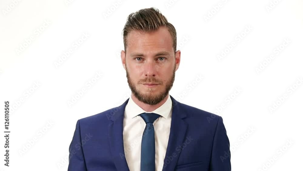 Video of a handsome businessman wearing a blue suit, blue tie and white shirt, standing in front of a white background. Video of a handsome businessman wearing a blue suit, blue tie and white shirt, standing in front of a white background.