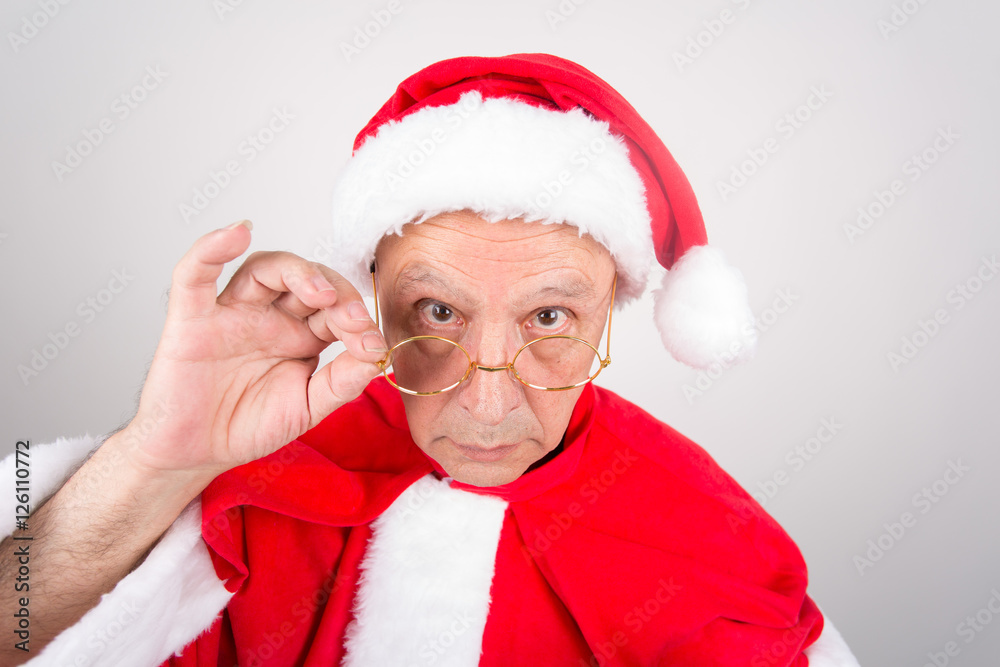 Senior in Weihnachtsmann Kostüm mit goldener Brille Senior in Weihnachtsmann Kostüm mit goldener Brille