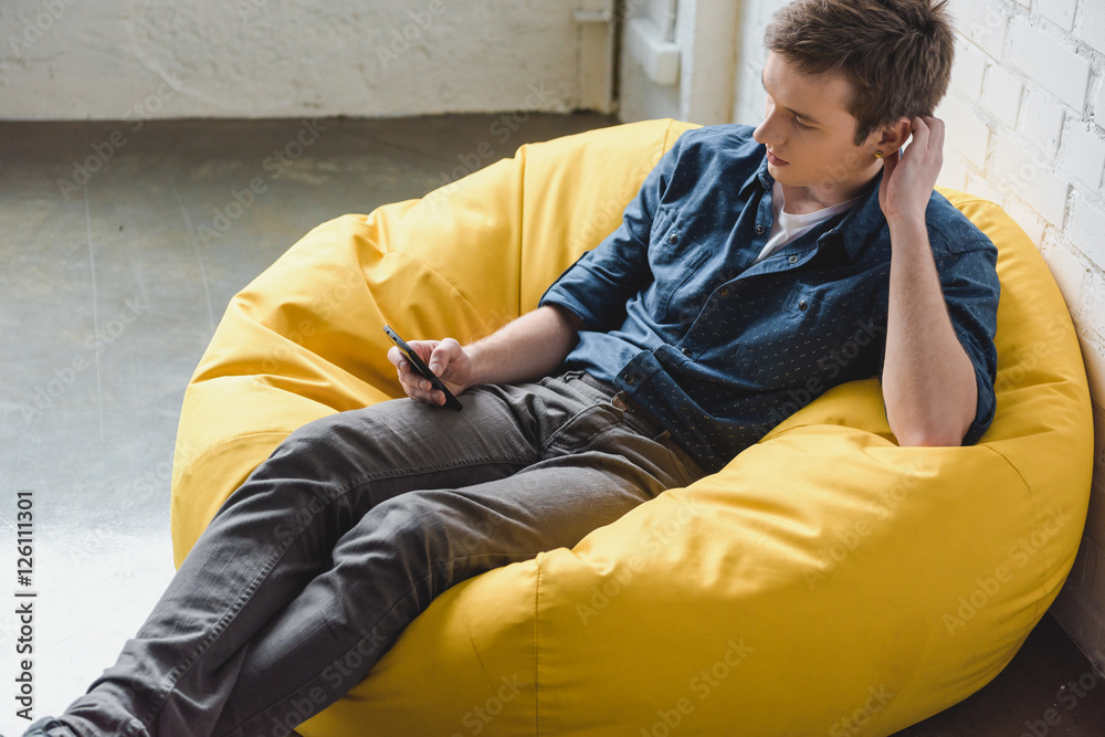 Attentive young man using smartphone Attentive young man using smartphone