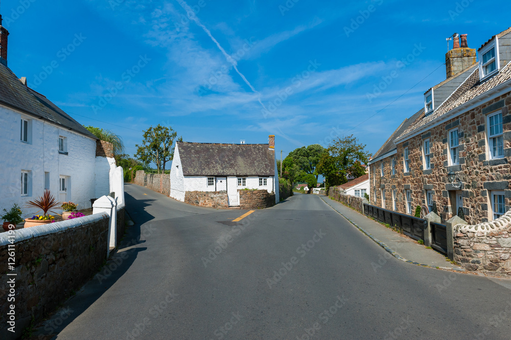 Street and Houses in village of Castel, Guernsey, Channel Islands, UK on summer day.