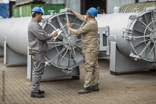 Workers in factory checking horizontal retort