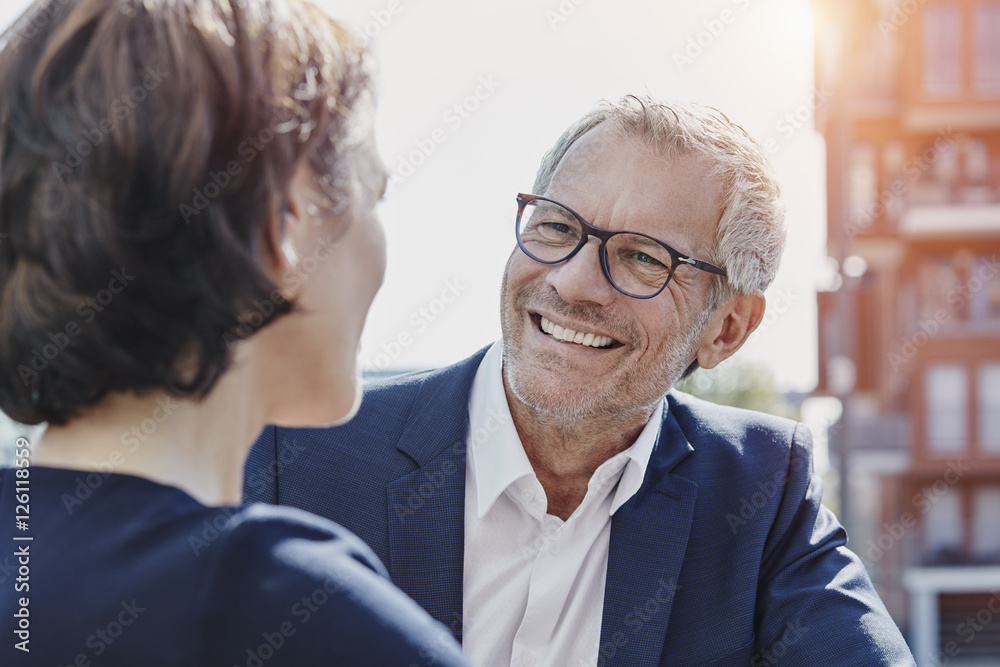 Businessman and businesswoman talking outdoors Businessman and businesswoman talking outdoors